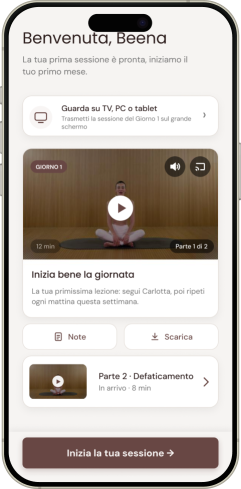 Schermata iniziale dell'app Pilates Diastasi e Post Parto con un messaggio di benvenuto personalizzato e la prima sessione di Carlotta Gagna, "Inizia bene la giornata", seduta a gambe incrociate su un tappetino
