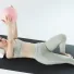 Esercizio di Pilates post parto: Carlotta Gagna distesa su un tappetino che tiene una palla da Pilates sopra il petto, per rinforzare il core e la parete addominale e ridurre la diastasi, nel programma Pilates Diastasi e Post Parto