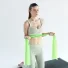 Esercizio di Pilates post parto: Carlotta Gagna in ginocchio su un tappetino che tende un elastico da Pilates tra le mani, per rinforzare il core e la parte superiore del corpo, nel programma Pilates Diastasi e Post Parto