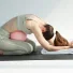 Esercizio di Pilates post parto: Carlotta Gagna in raccoglimento in avanti su un tappetino con una palla da Pilates all'addome, per distendere la schiena e rilassare il pavimento pelvico, nel programma Pilates Diastasi e Post Parto