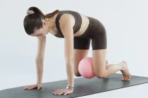 Esercizio di Pilates post parto: Carlotta Gagna in quadrupedia con una palla da Pilates dietro le ginocchia, per rinforzare il core e la parete addominale e ridurre la diastasi, nel programma Pilates Diastasi e Post Parto