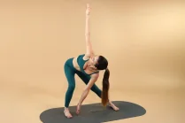 Sessione Lifestyle + Gambe e glutei con Carlotta Gagna che esegue un allungamento laterale in piedi con un braccio disteso sopra la testa