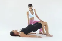 Esercizio di Pilates in gravidanza: Carlotta Gagna guida una donna nella posizione del ponte per rinforzare glutei e pavimento pelvico, nel programma Pilates Linfodrenante® Gravidanza