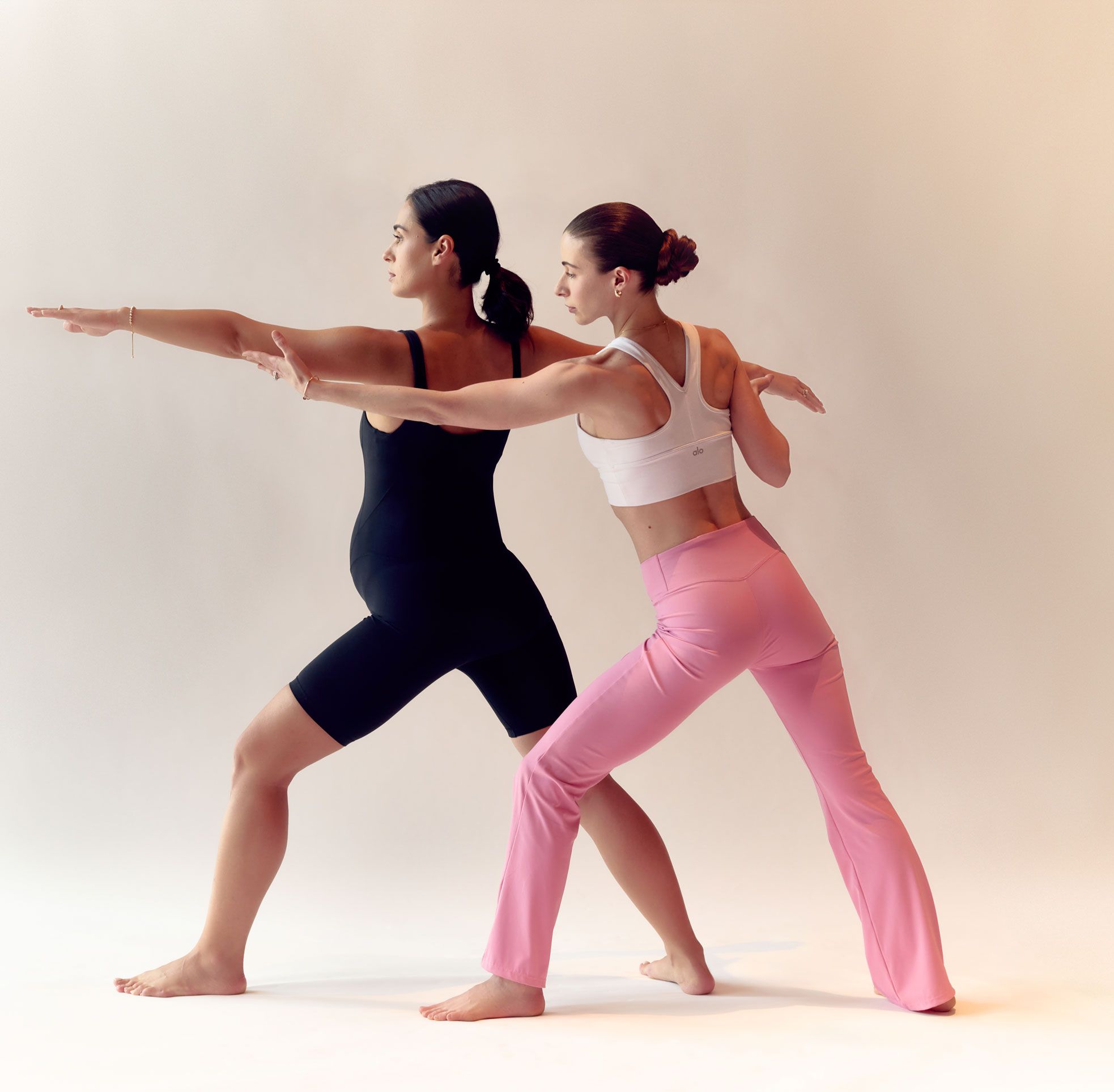 Allenatrice di Pilates che supporta una donna in gravidanza nell'esecuzione di un affondo laterale