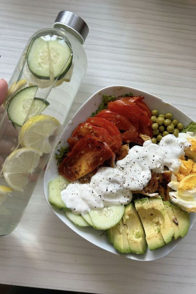 Anti-inflammatory bowl with avocado, eggs, vegetables, and lemon water — a healthy lifestyle combined with the Lymphatic Drainage Pilates method to promote drainage and reduce bloating.