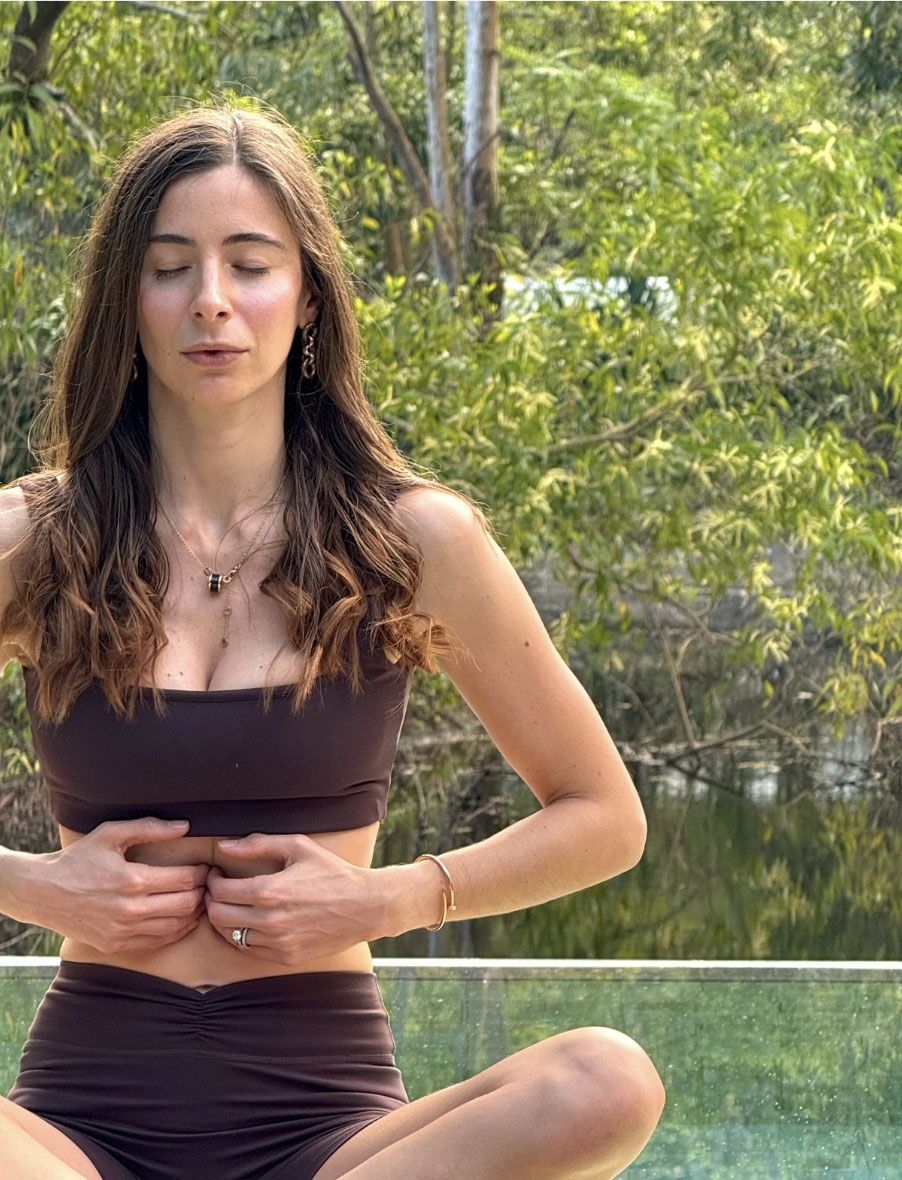 Carlotta Gagna seated with both hands on her chest performing diaphragmatic breathing.
