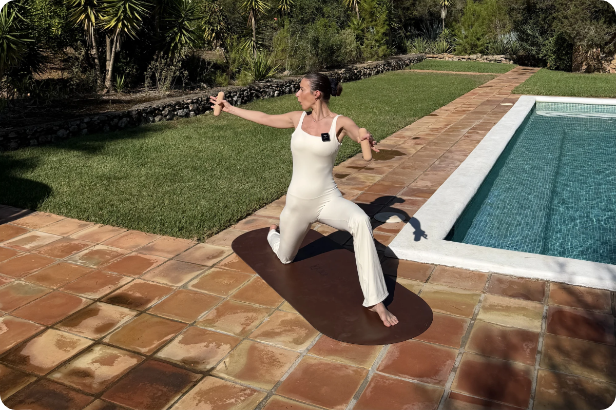 Carlotta Gagna doing a Lymphatic Drainage Pilates exercise on the mat by the pool in the morning