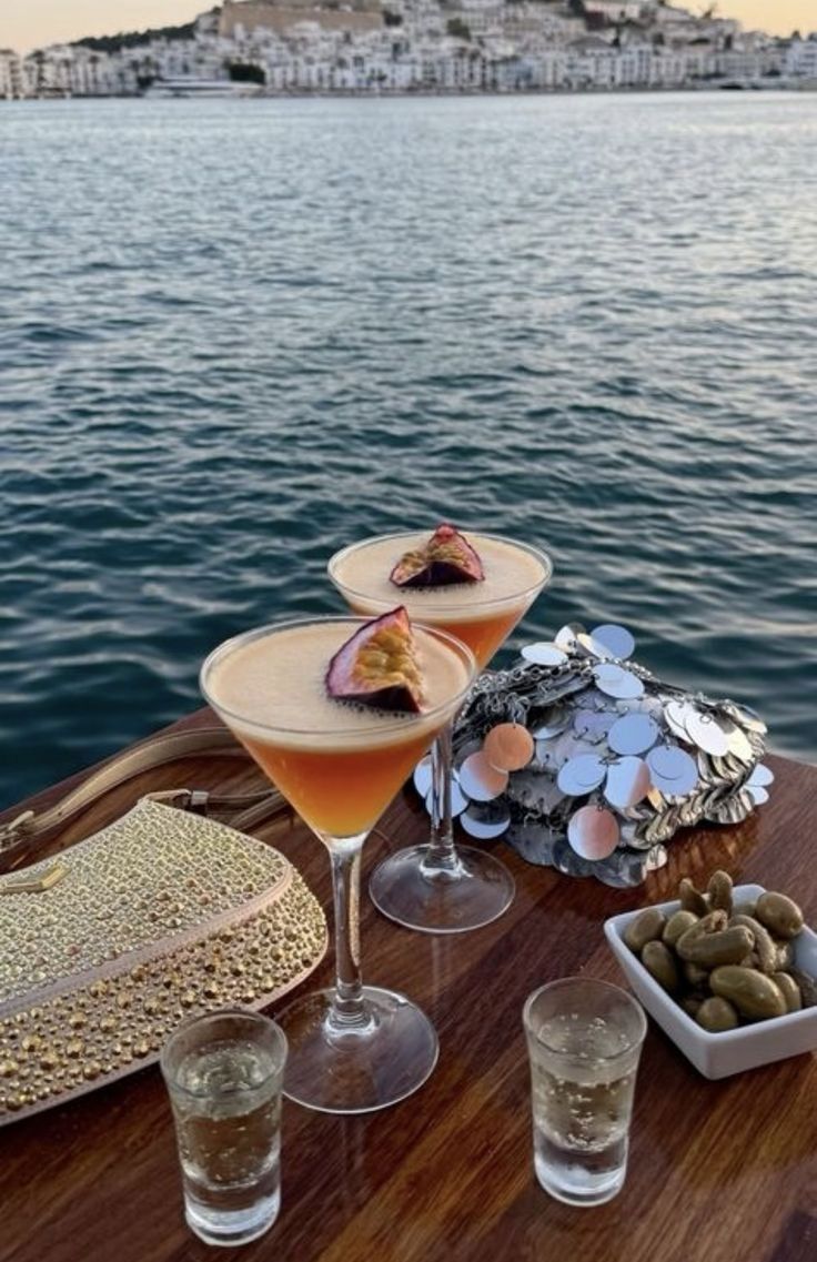 Due cocktail appoggiati su un tavolino in riva al mare al tramonto