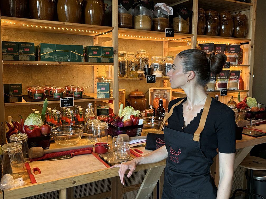 Carlotta Gagna di Traininpink in un laboratorio di cibi fermentati con barattoli e prodotti fermentati — alimentazione per la salute intestinale e il microbiota