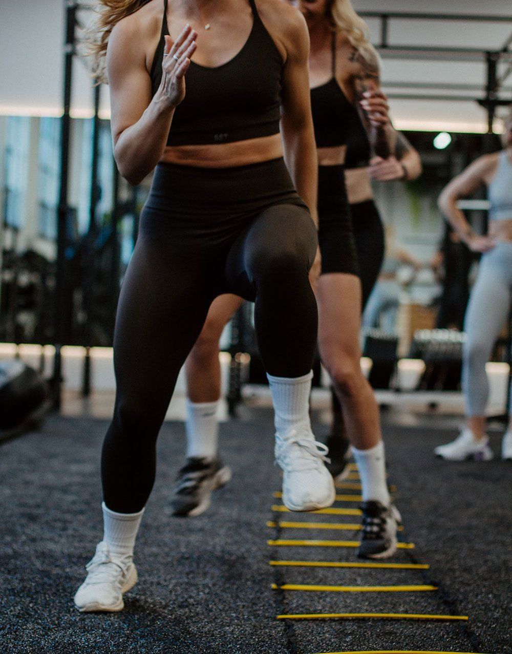 Donne eseguono allenamento HIIT ad alto impatto con salti in palestra — tipo di esercizio da evitare con il lipedema perché aumenta infiammazione e cortisolo