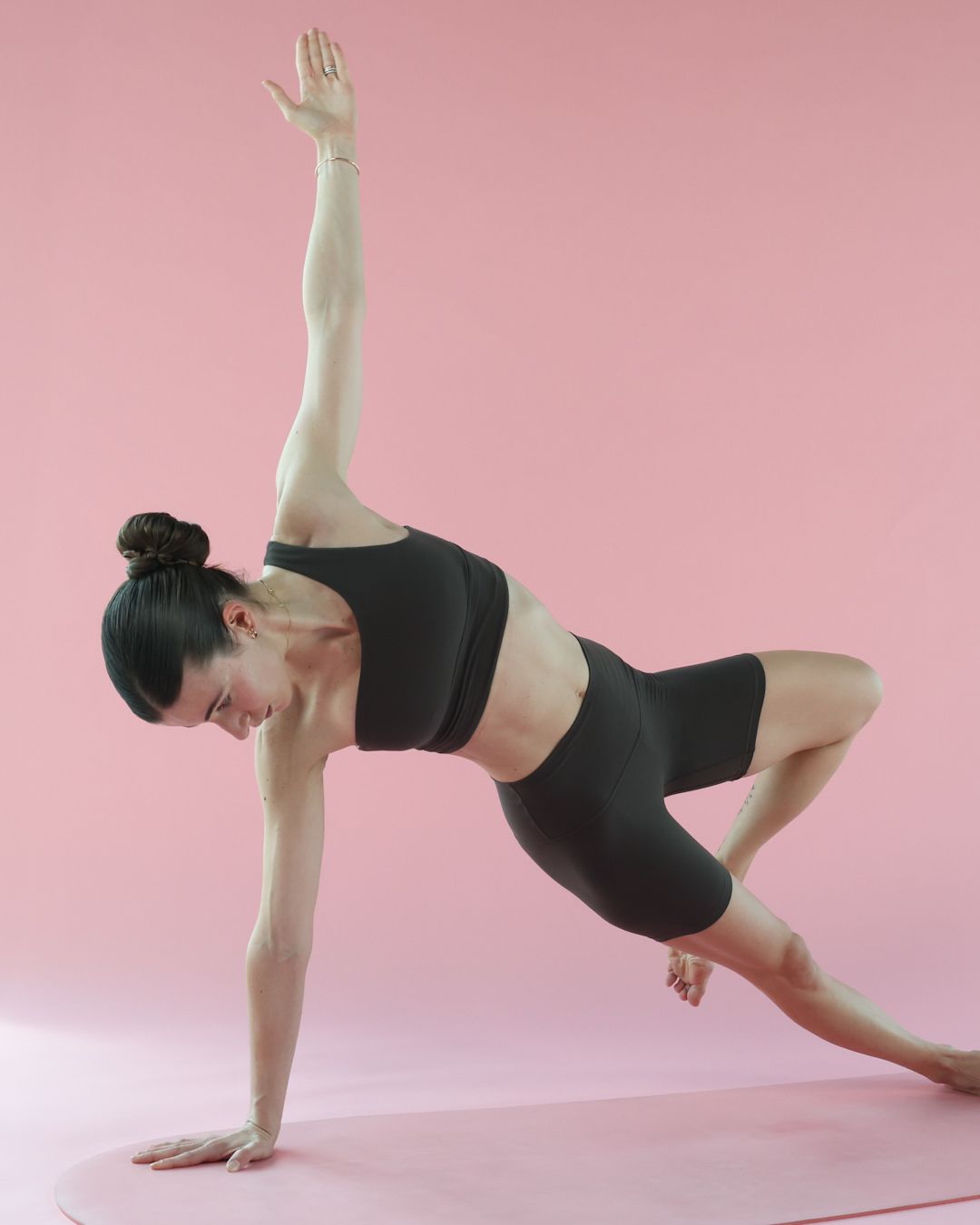 Carlotta Gagna esegue una planche laterale con rotazione sul tappetino, esercizio per risvegliare i muscoli profondi e ridurre l'infiammazione cronica con il Pilates Linfodrenante