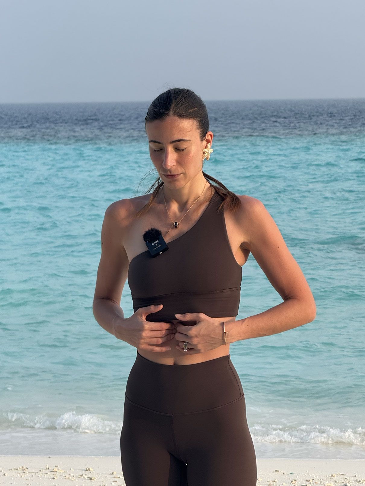Carlotta Gagna che esegue un esercizio di respirazione diaframmatica in spiaggia