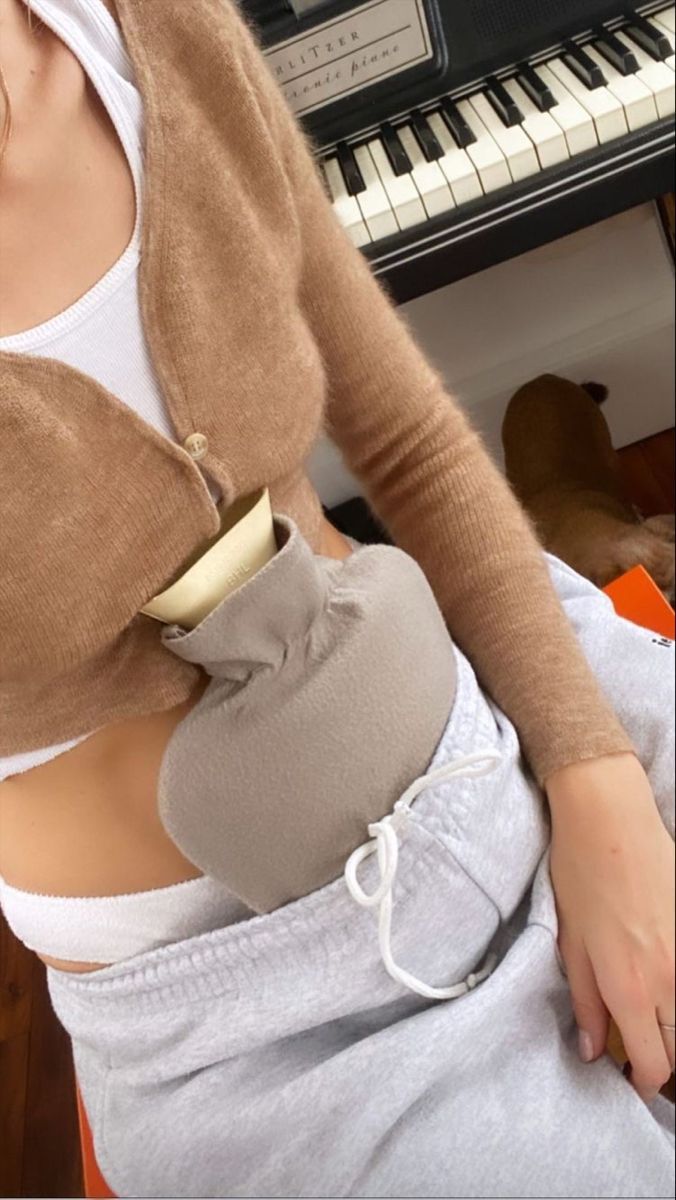 Donna seduta con una borsa dell'acqua calda appoggiata sull'addome