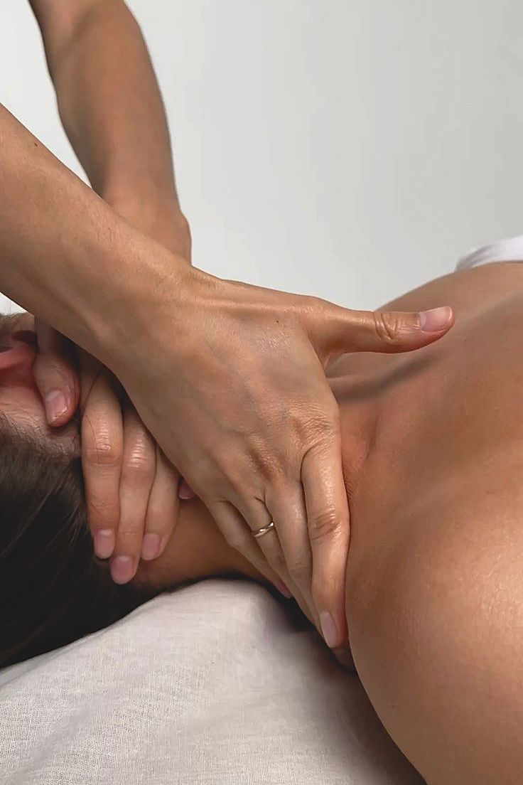 Foto delle mani di una terapista che esegue un massaggio linfodrenante, con focus su collo e cervicali