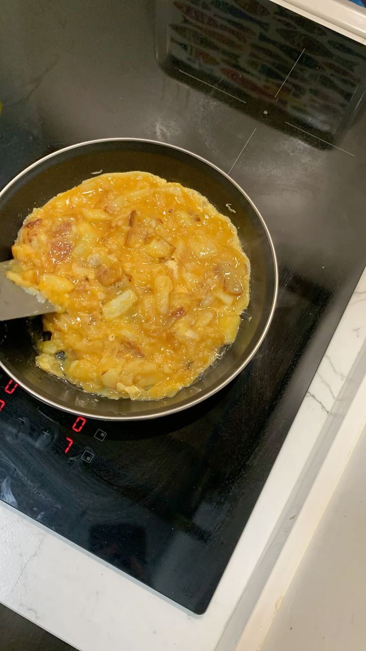 Frittata con pancetta e cipolla cotta su pentola antiaderente e fornello elettrico