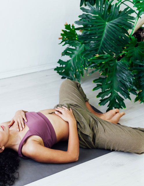 Donna supina a terra che esegue i kegel per il pavimento pelvico