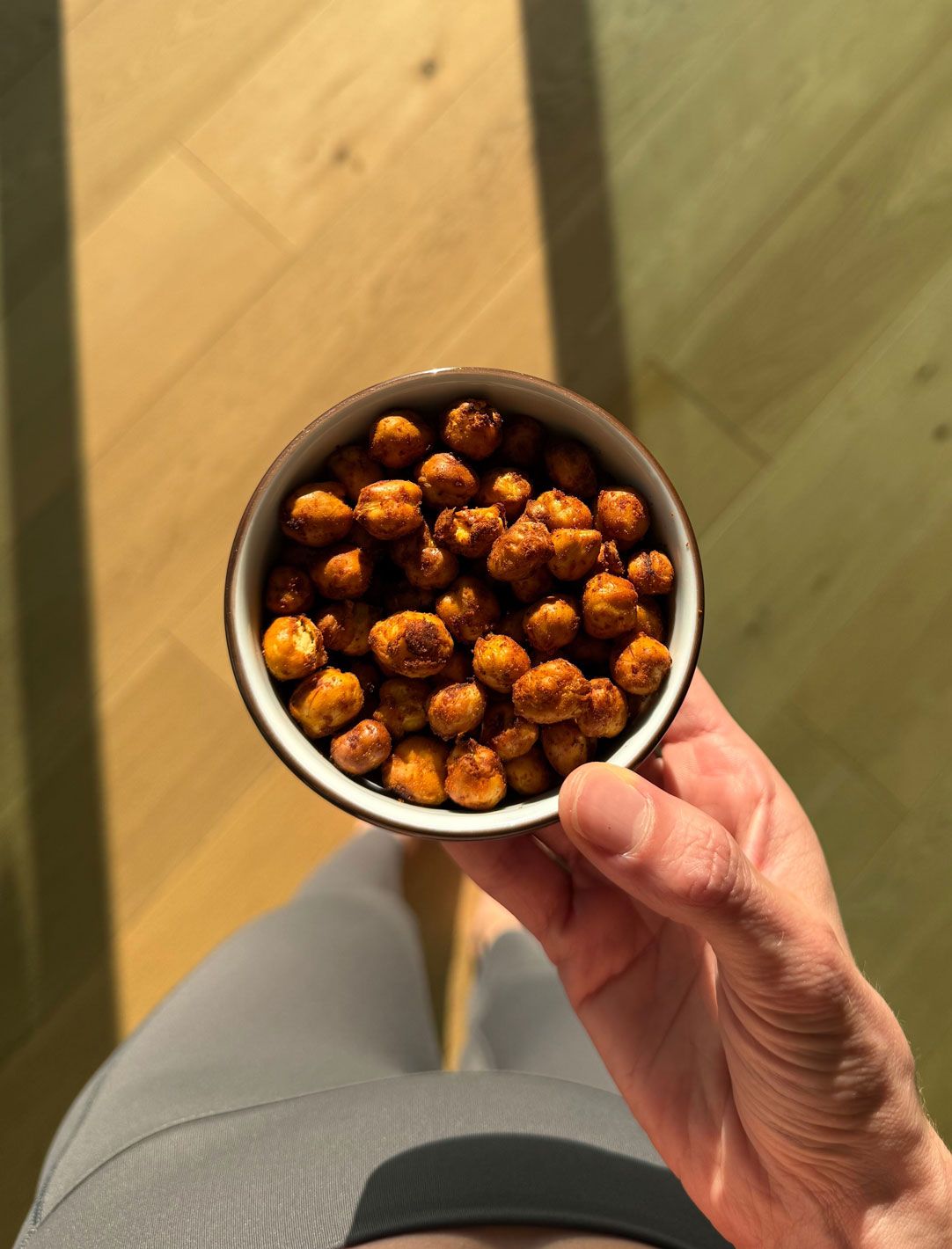 Donna che tiene in mano una ciotolina di ceci tostati alla paprika