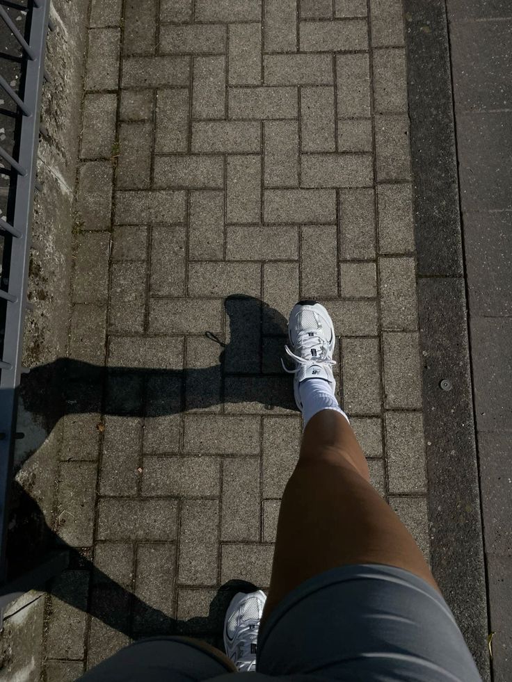 Gambe in movimento durante una camminata mattutina all'aperto — abitudine che regola il cortisolo e il ritmo circadiano dopo una notte insonne