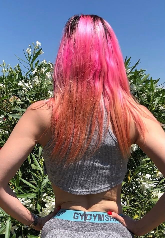 Carlotta Gagna con capelli tinti di rosa — fase di colorazioni aggressive che ha portato a capelli sfibrati e alla ricerca di soluzioni nutrizionali per la salute dei capelli
