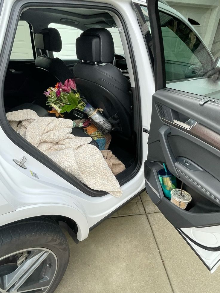 Sedili posteriori di un'auto con un mazzo di fiori e sporte della spesa