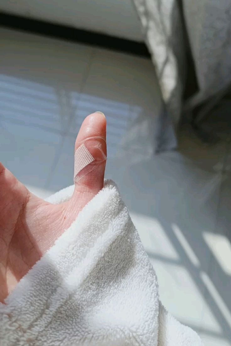 Mano di donna con cerotto sul pollice