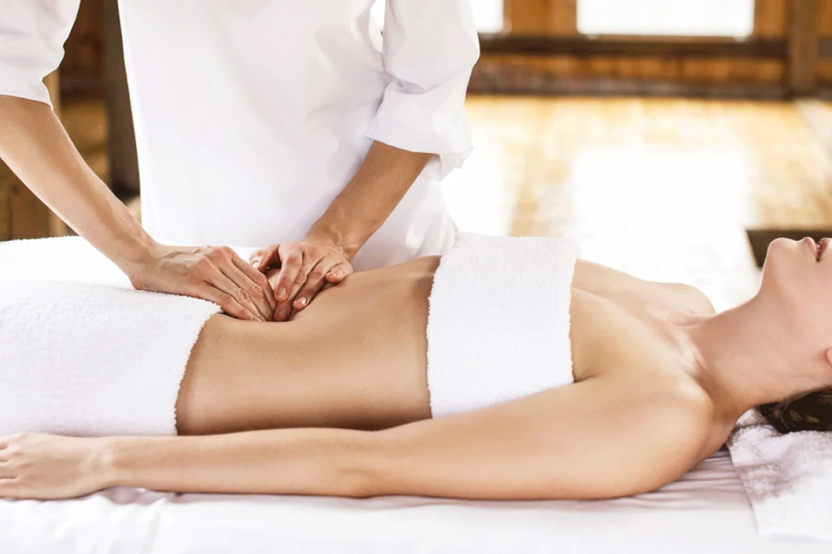 Drenaggio linfatico manuale sulle gambe eseguito da un'operatrice, con manovre lente e leggere