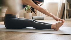 Donna seduta a terra su tappetino che esegue una sessione di Pilates Linfodrenante Express di prima mattina